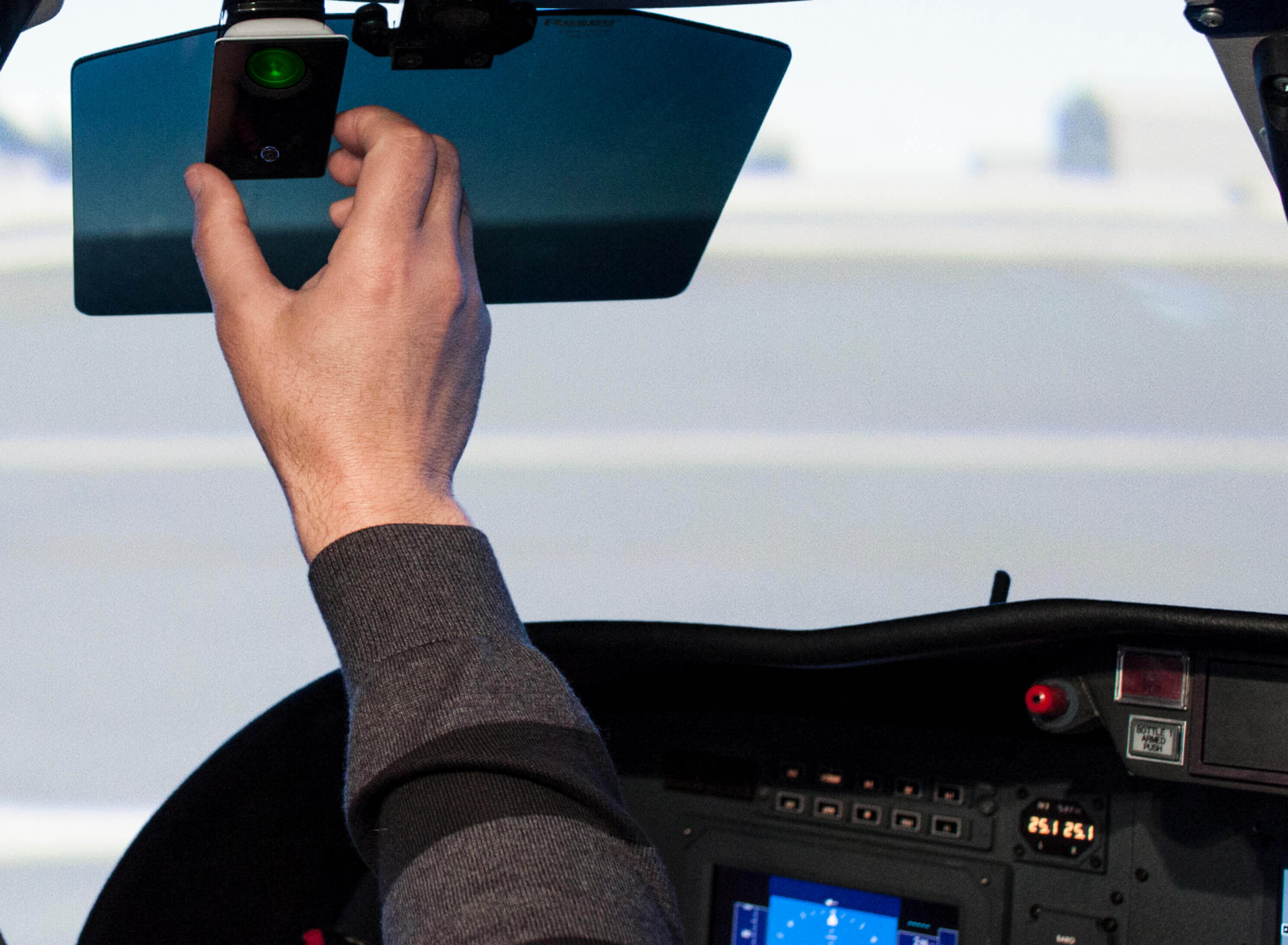 A pilot reaching for their handheld oxygen monitor.