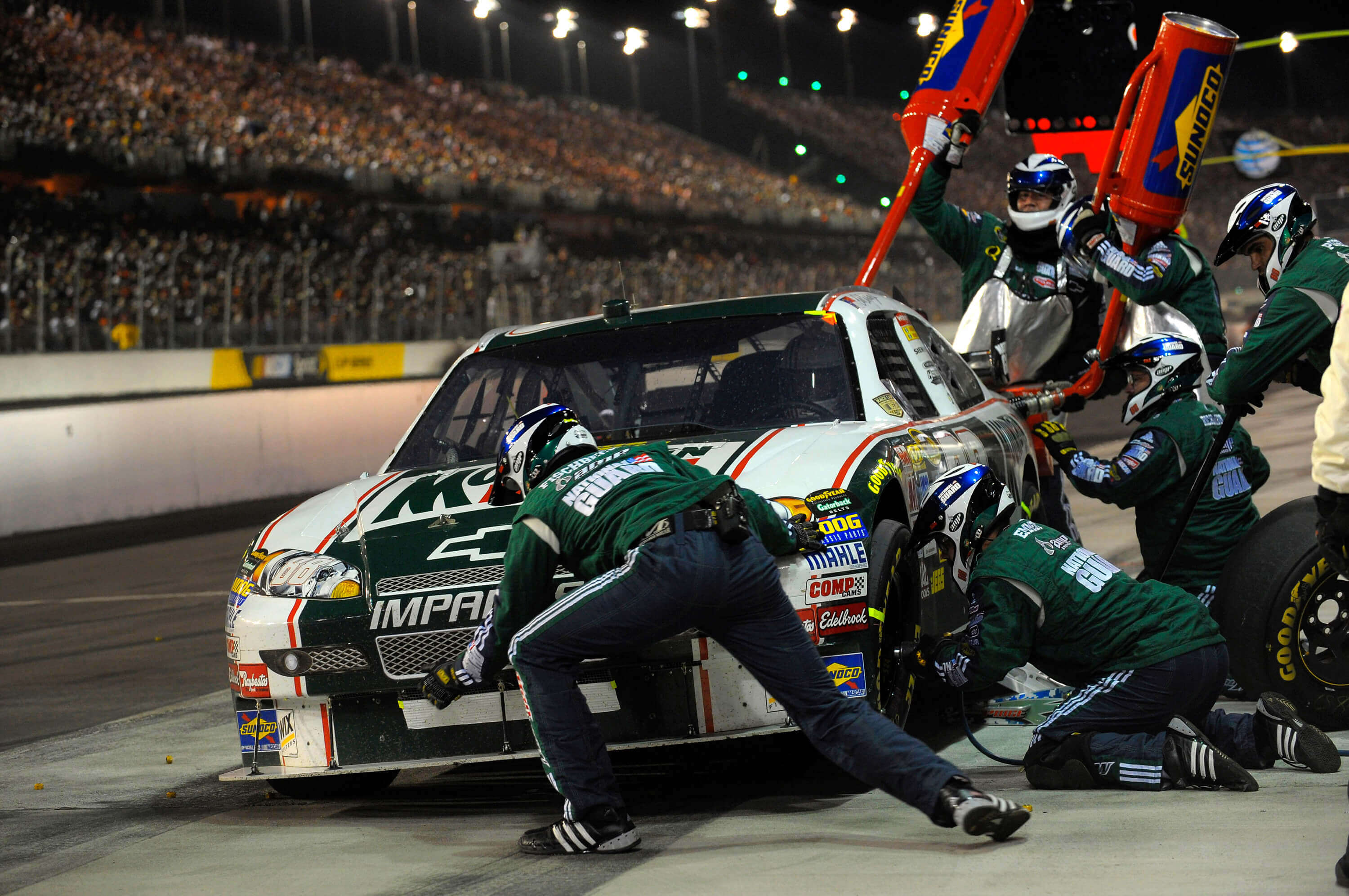 Professional racing team pit crew servicing a racecar