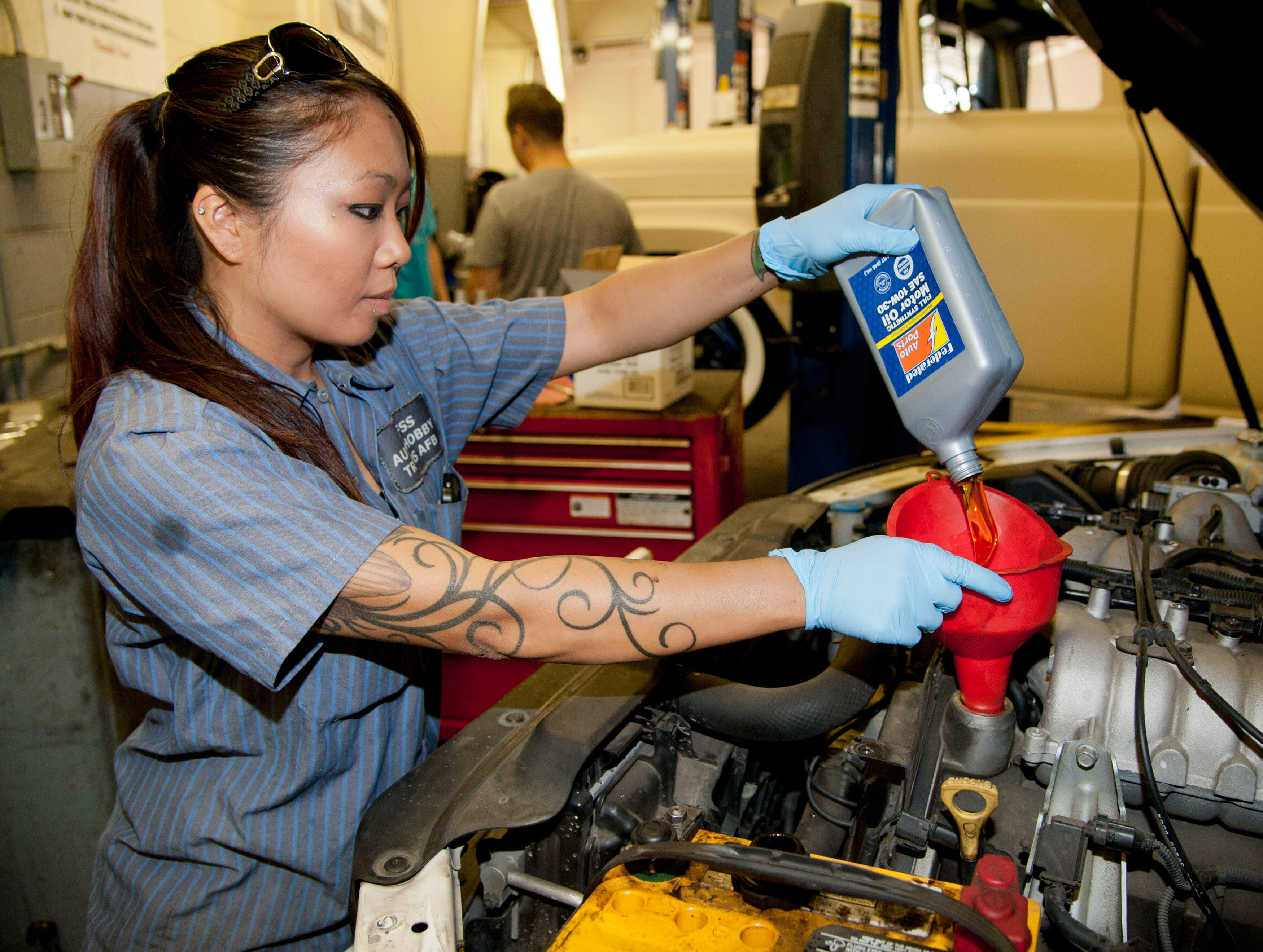 Worker changing the oil in a car