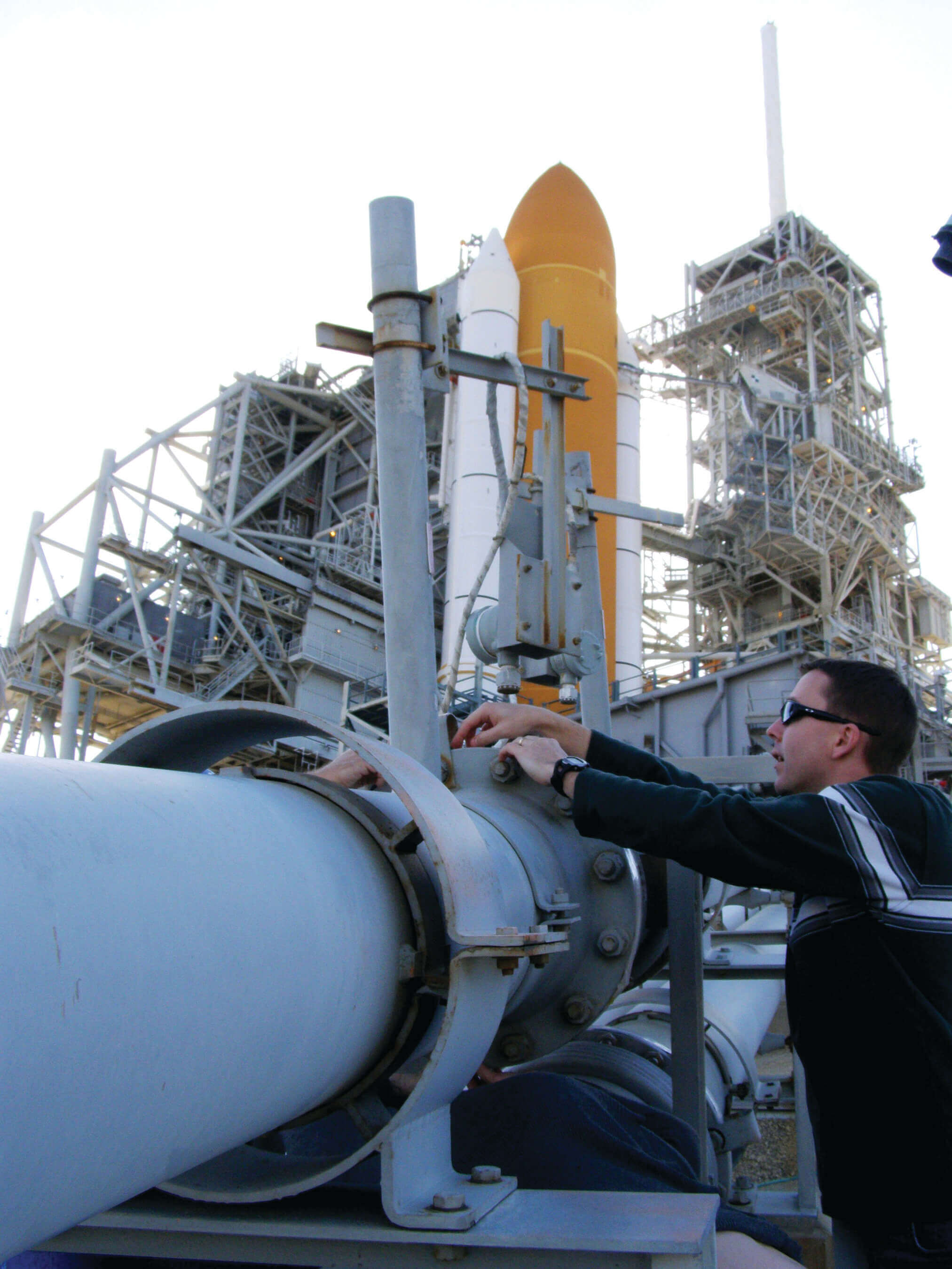 NASA personnel inspecting fuel lines where hydrogen leaks are suspected
