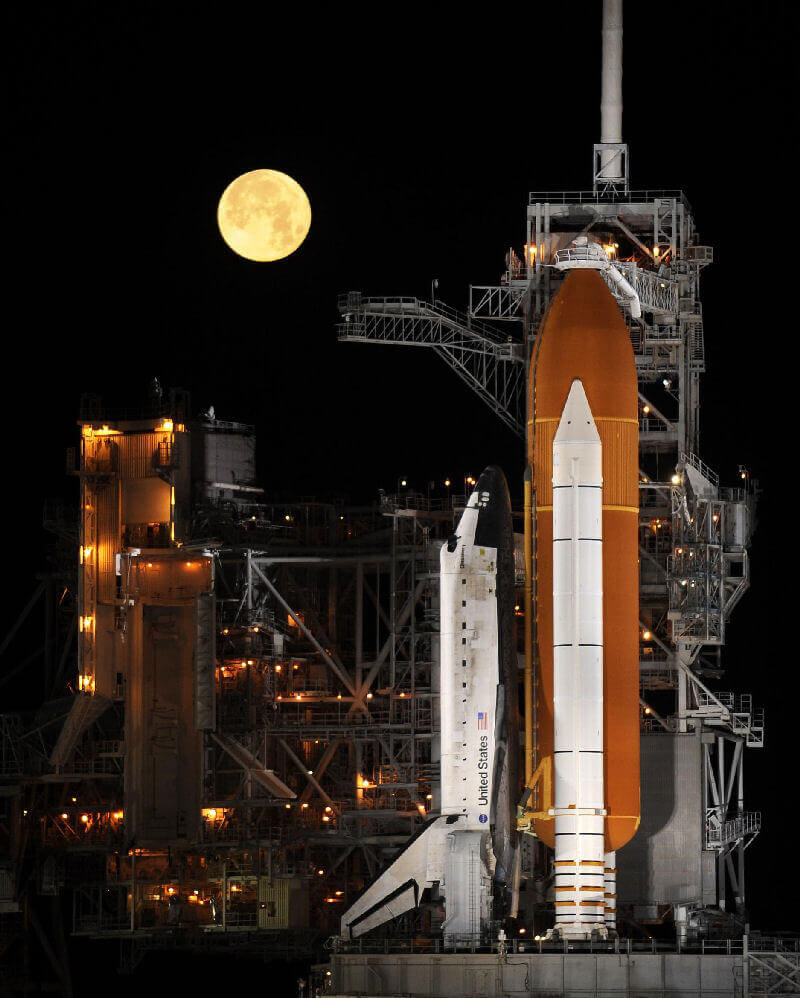 A space shuttle on the launch pad at night