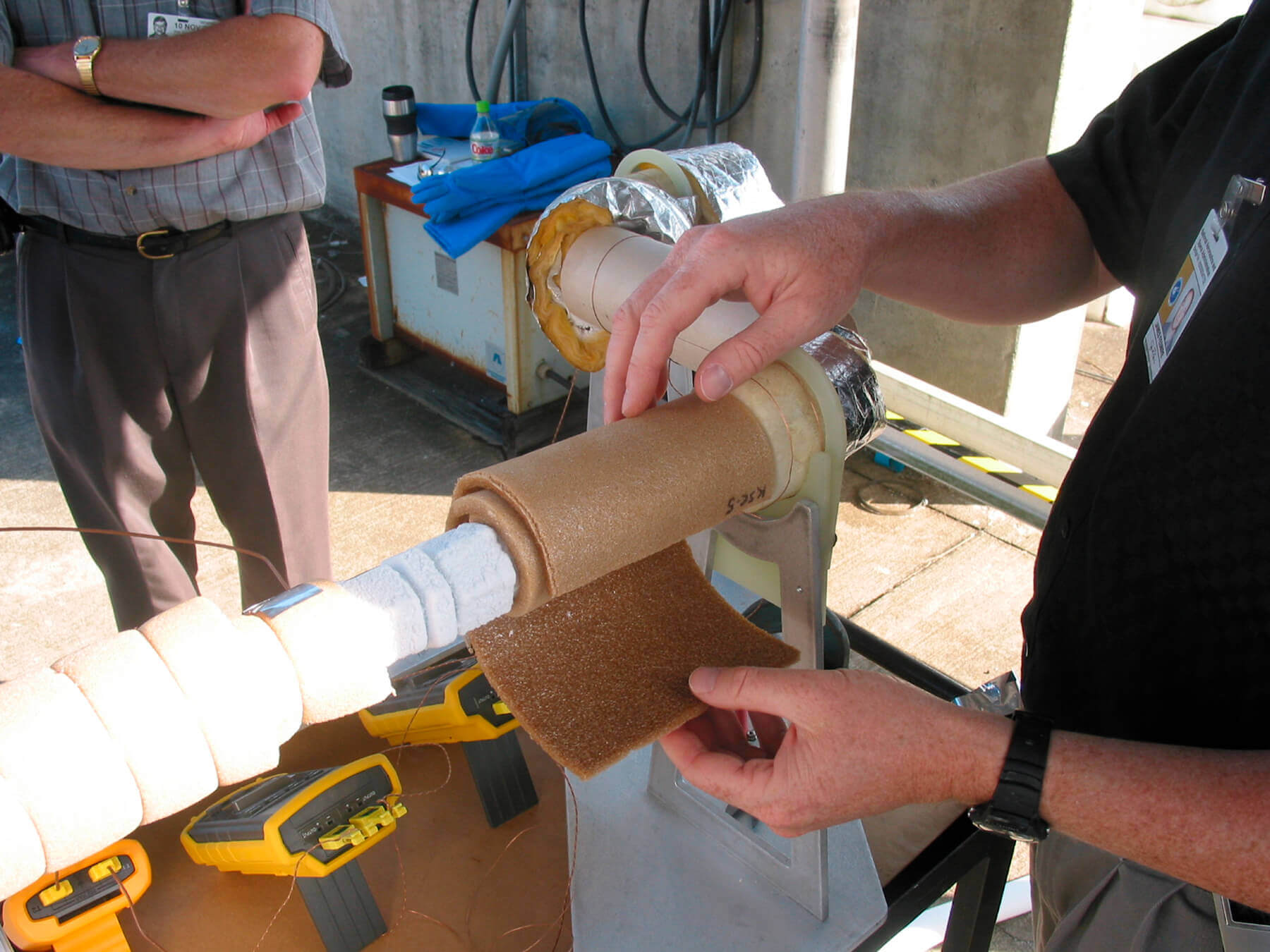Man insulating a pipe using a NASA-created foam