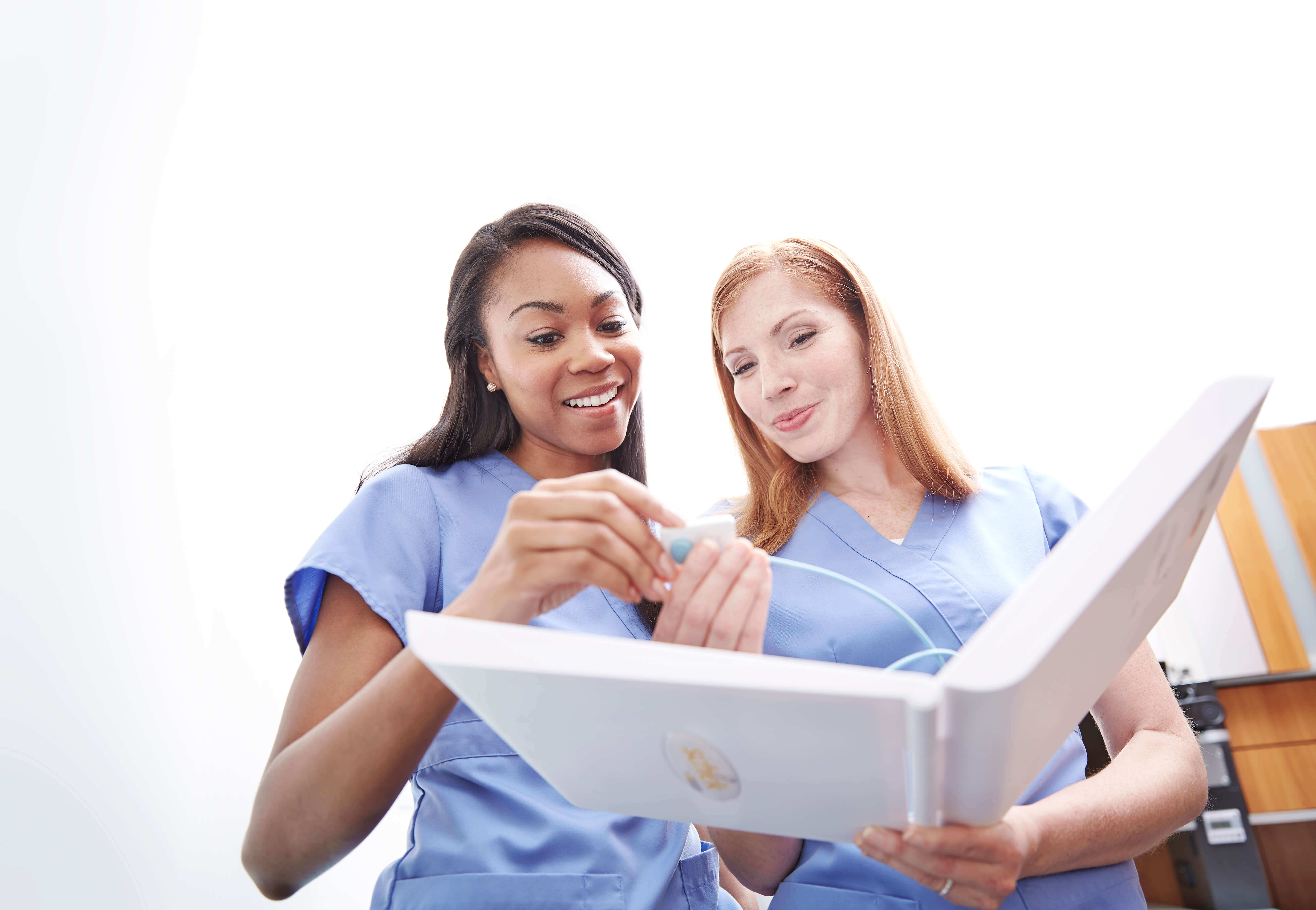 Two dental workers use a dental imager with a laptop 