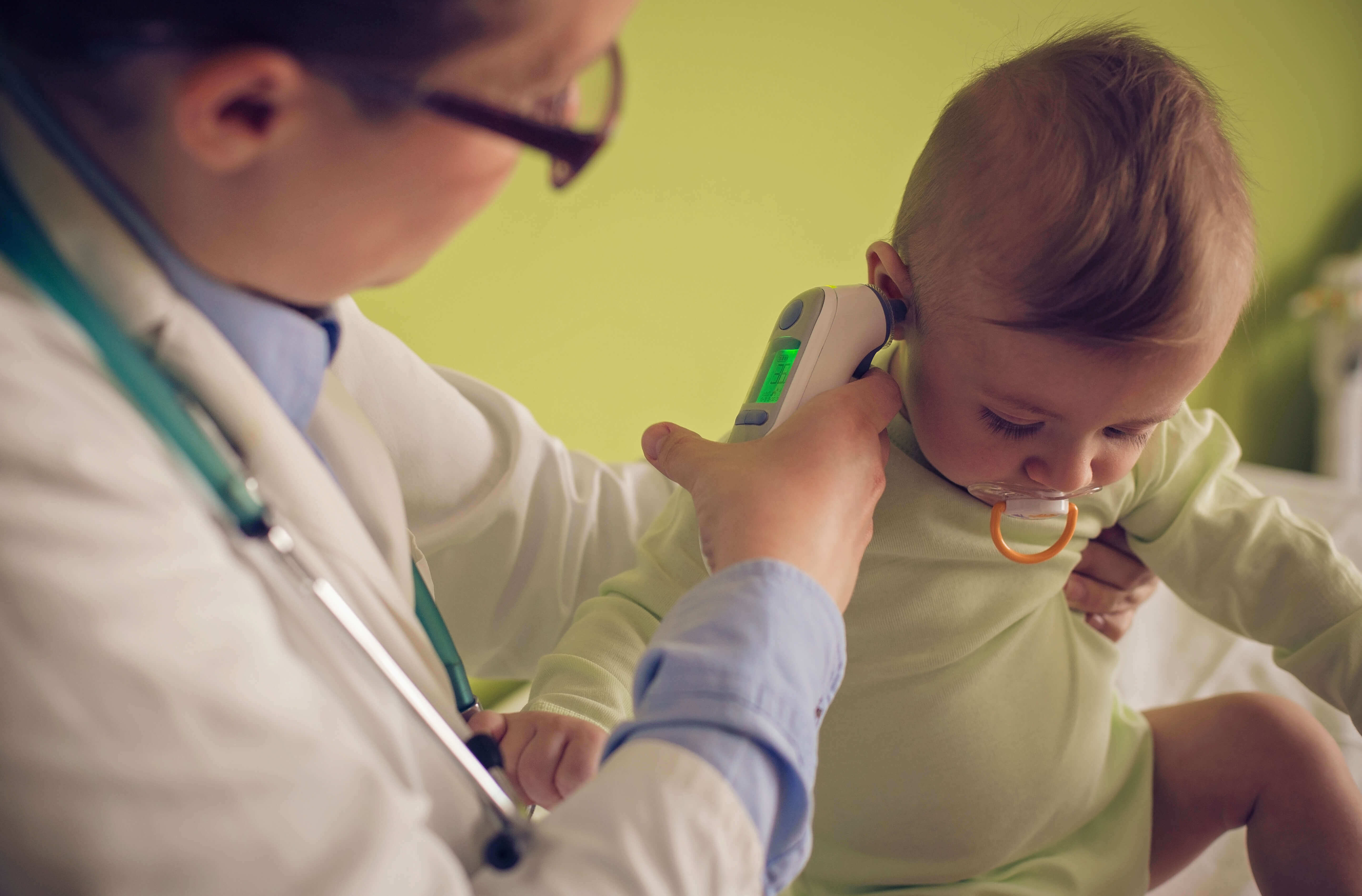 Doctor taking the temperature of a baby