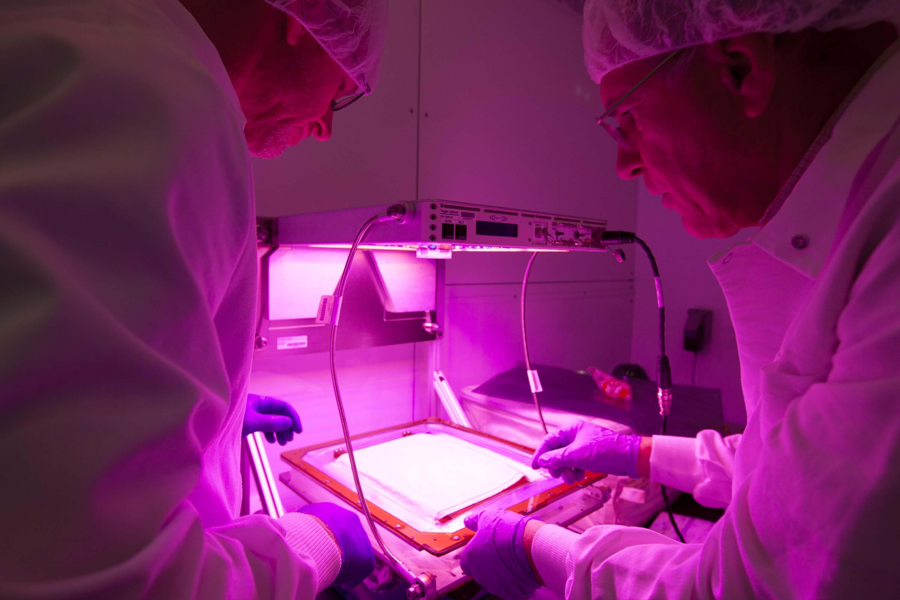 NASA personnel working with an LED device