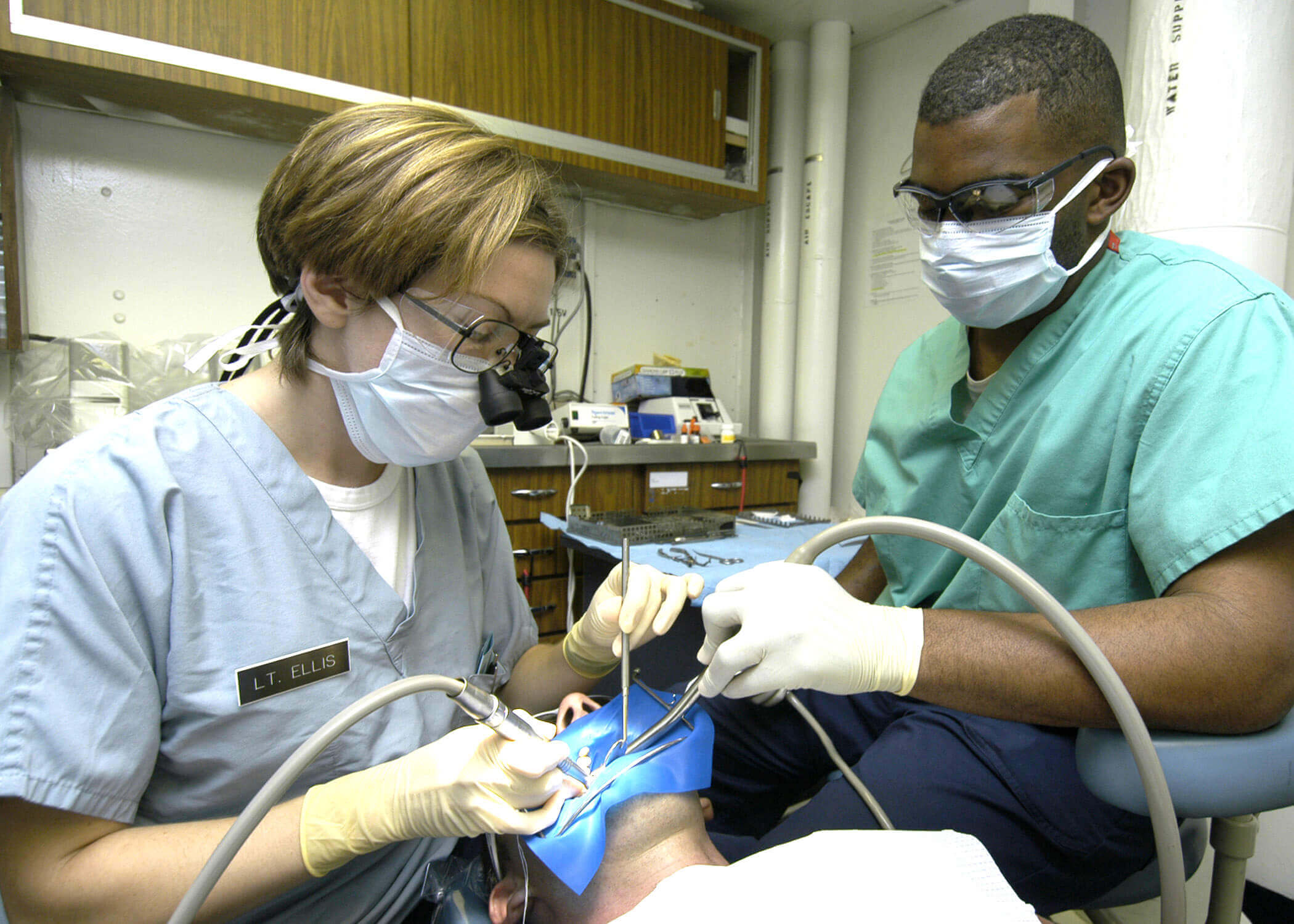 Dental workers work on a patient's teeth 