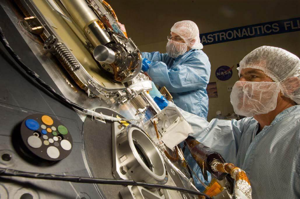 Technicians working on the Phoenix Mars Lander in a clean room 