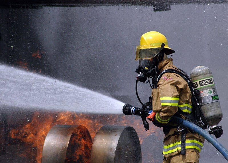 Firefighter using a firehose