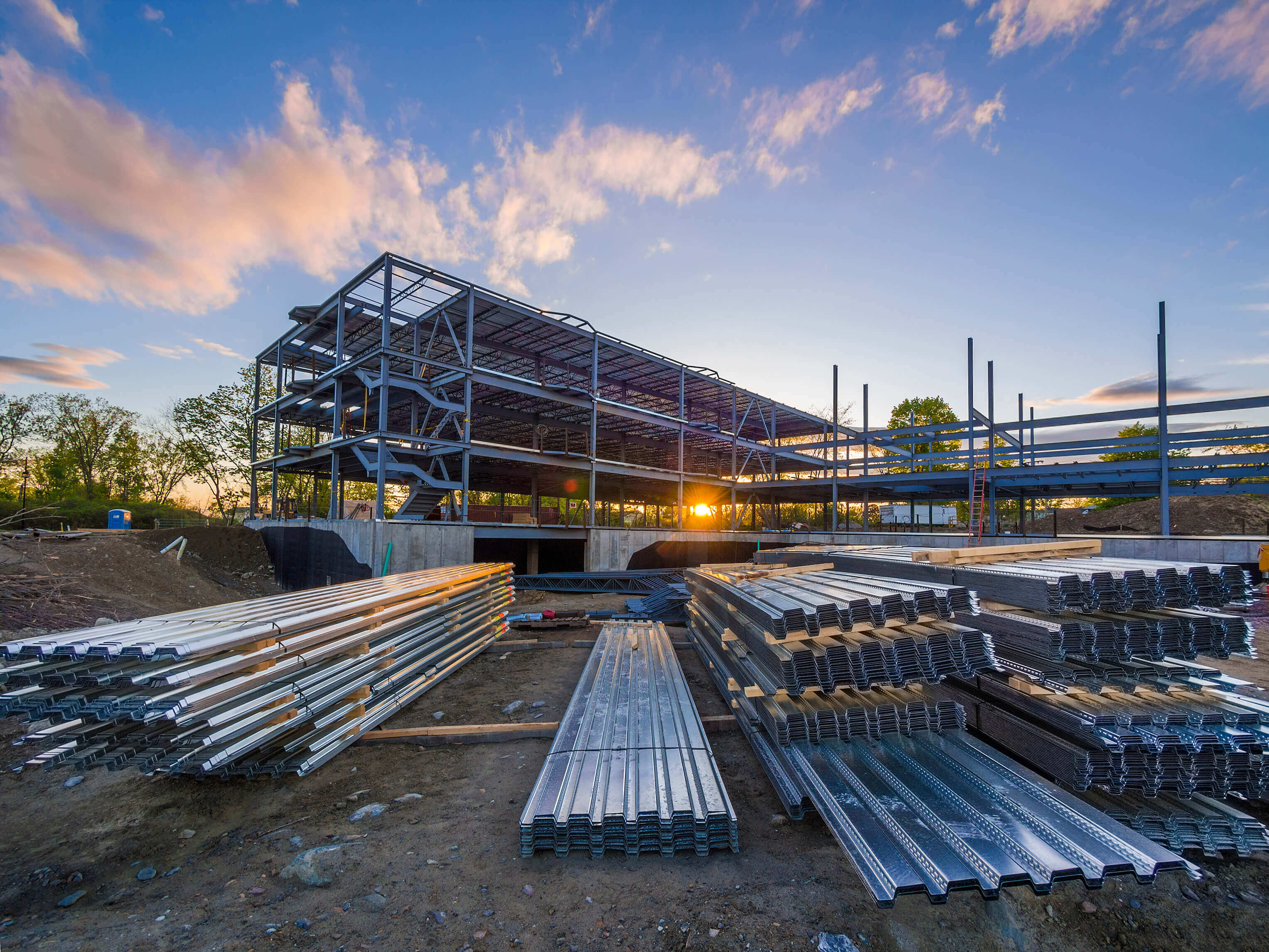 Sheets of metal lie beside building under construction 