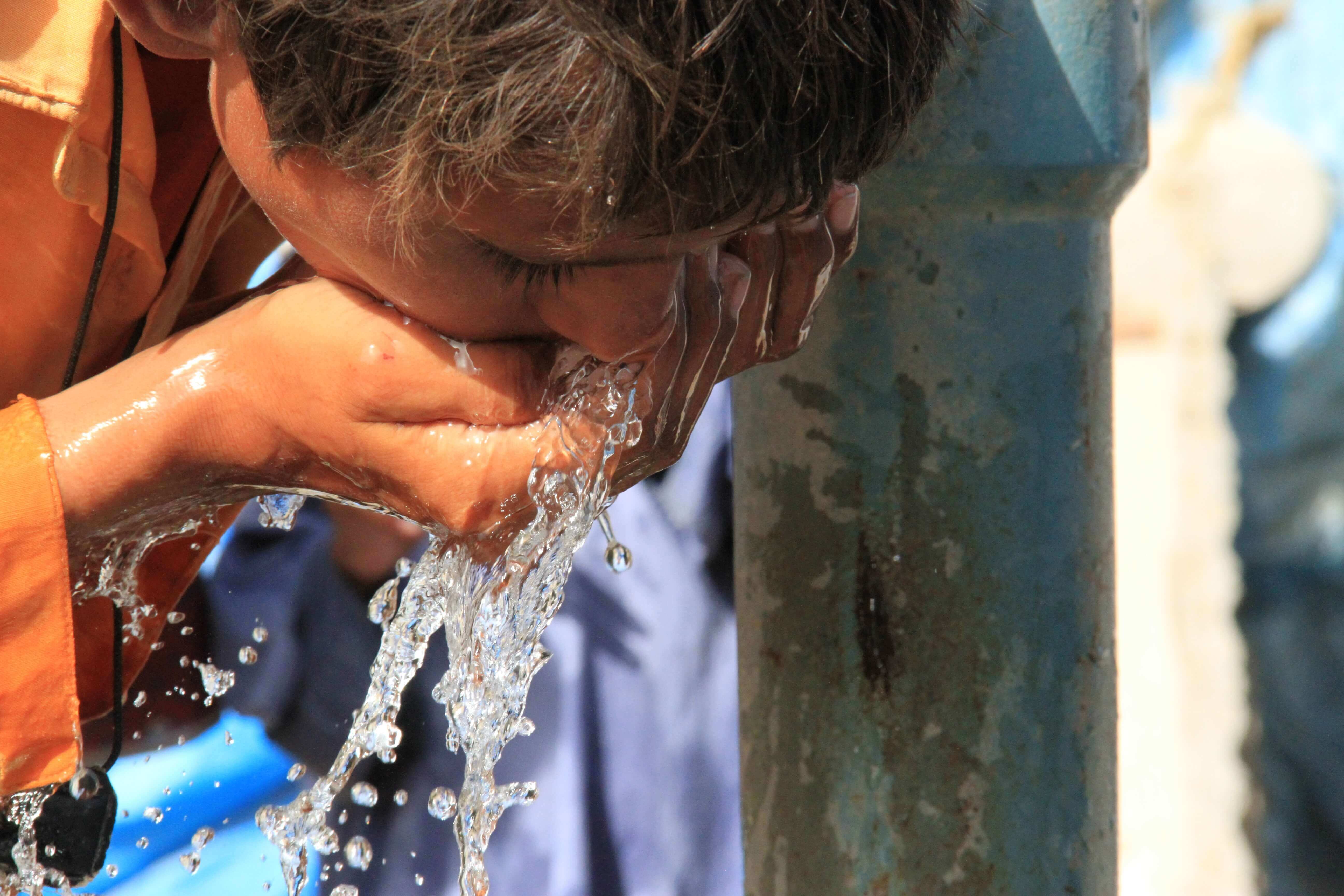 Child drinking clean water from a well