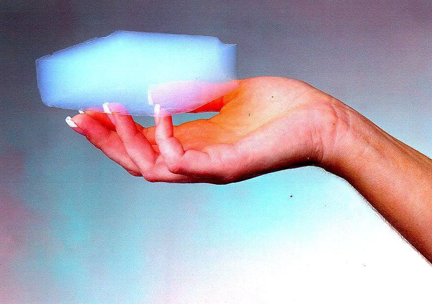 Person holding a block of aerogel, one of the world's lightest solids and most effective insulators