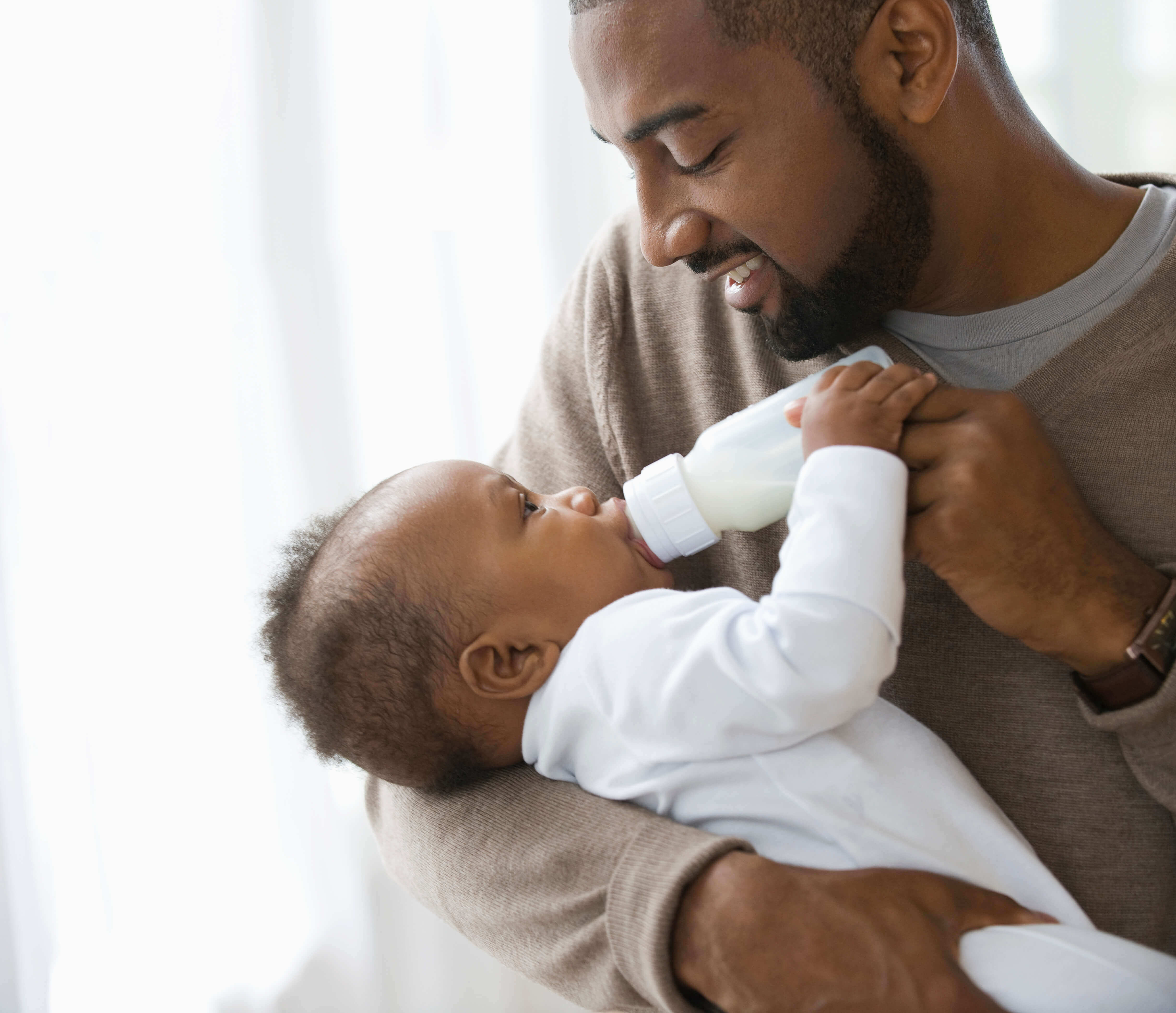 Dad feeding an infant some formula