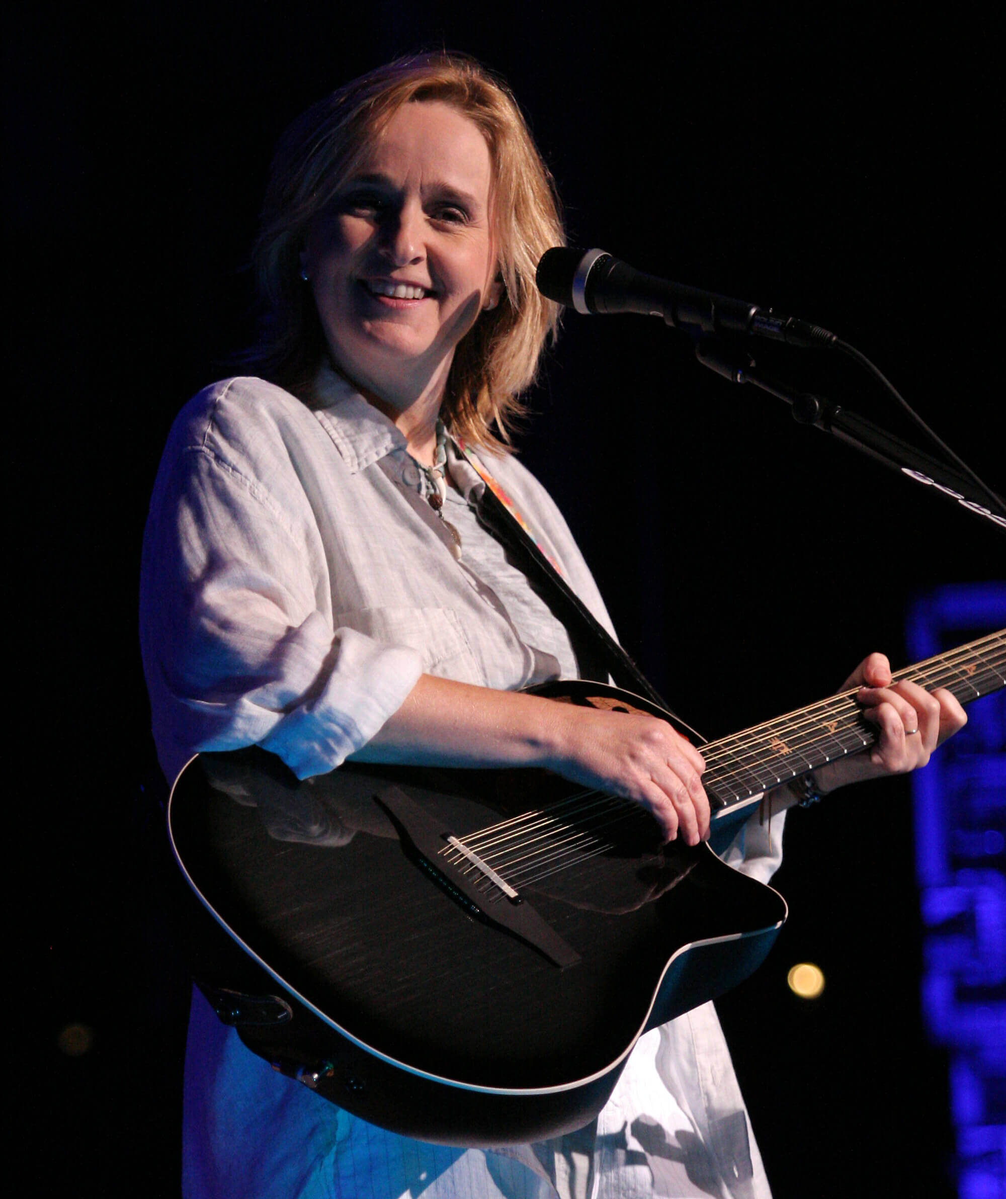 Artist Melissa Etheridge in concert holding an Ovation guitar