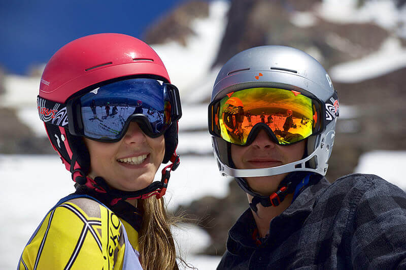 Two skiers wearing blue-light-canceling lenses