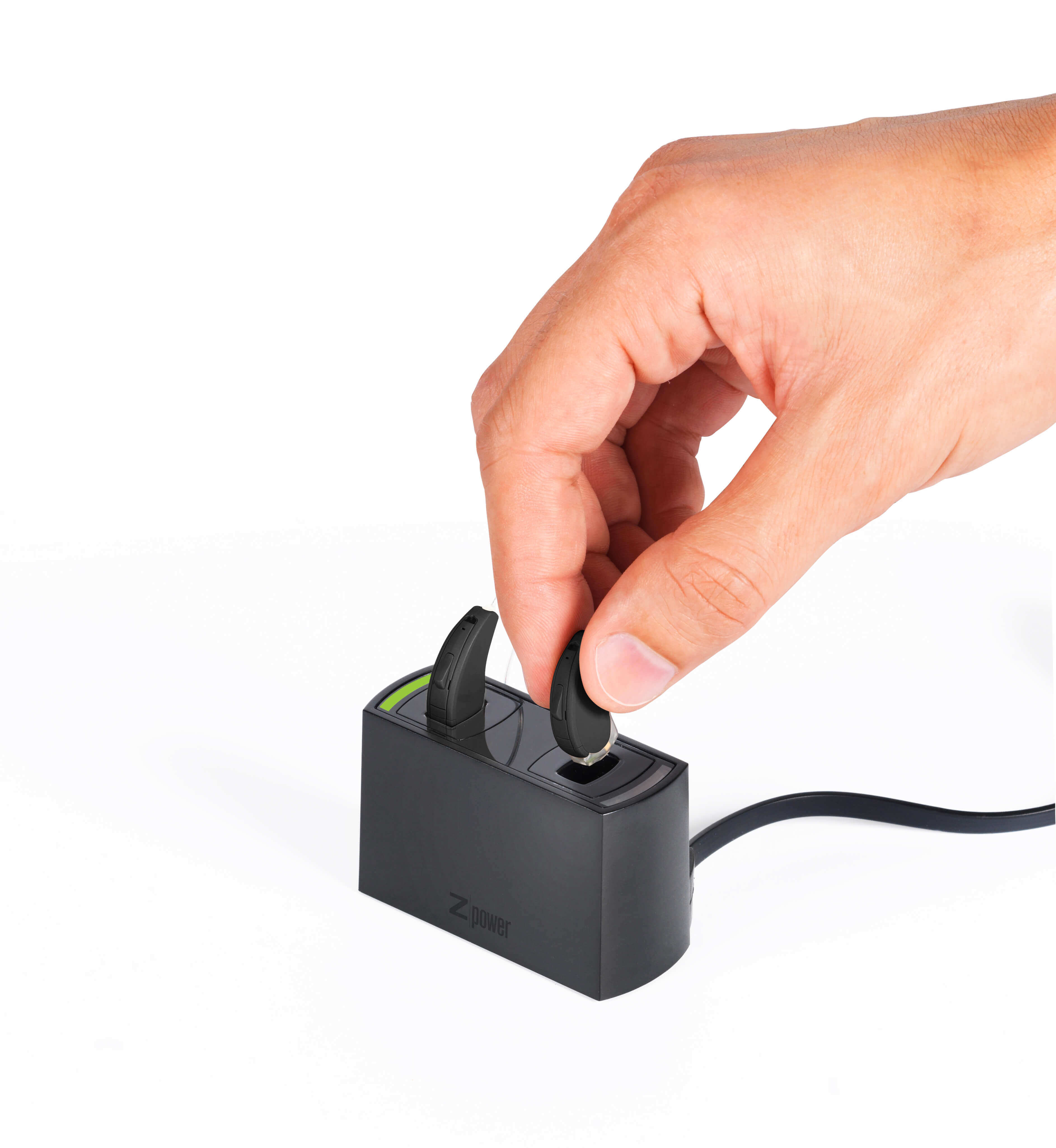 Person placing hearing aids into a recharger station