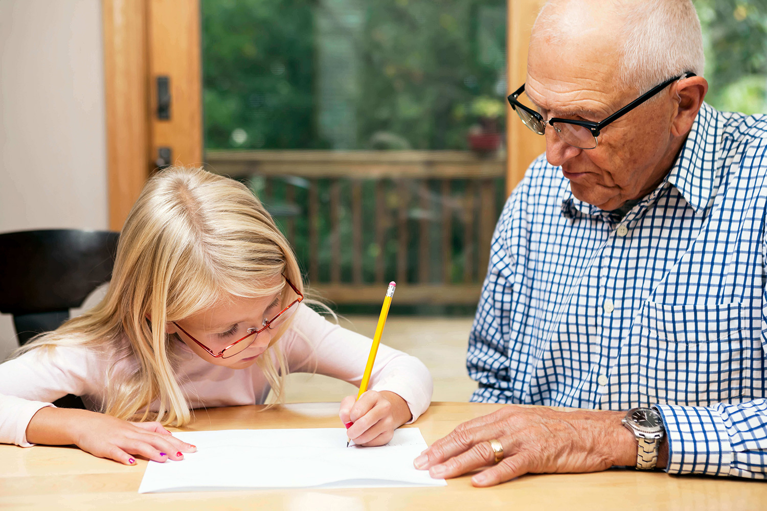 Grandfather helping his granddaughter with her homework