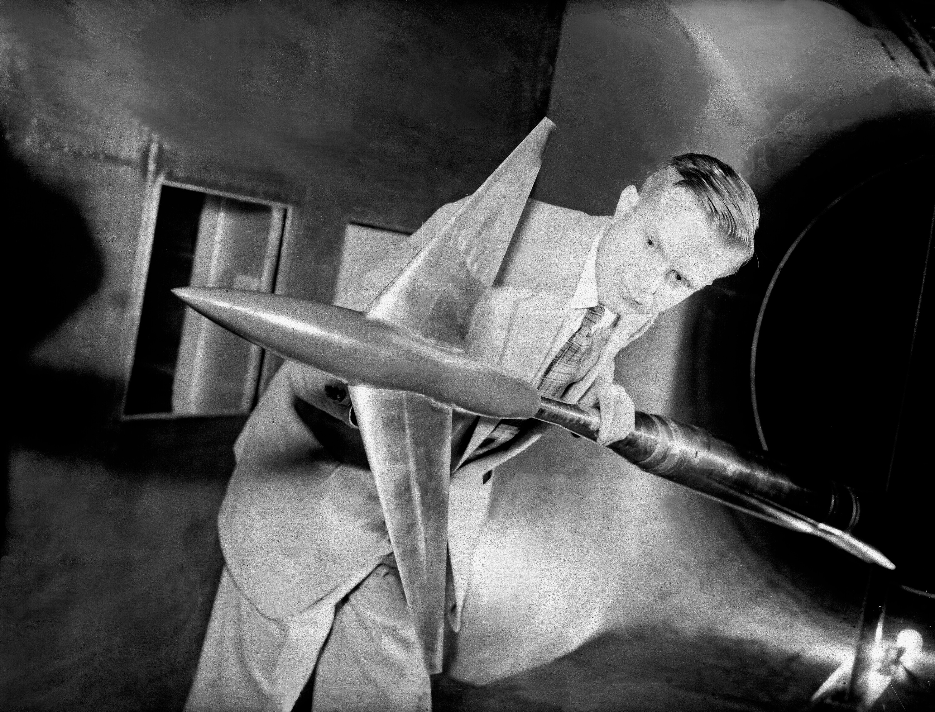 A historical photo of a researcher examining a model.