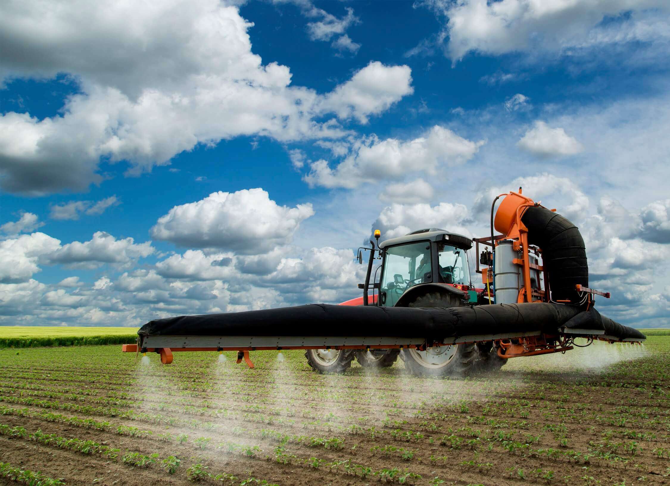 Tractor spraying fertilizer on a field