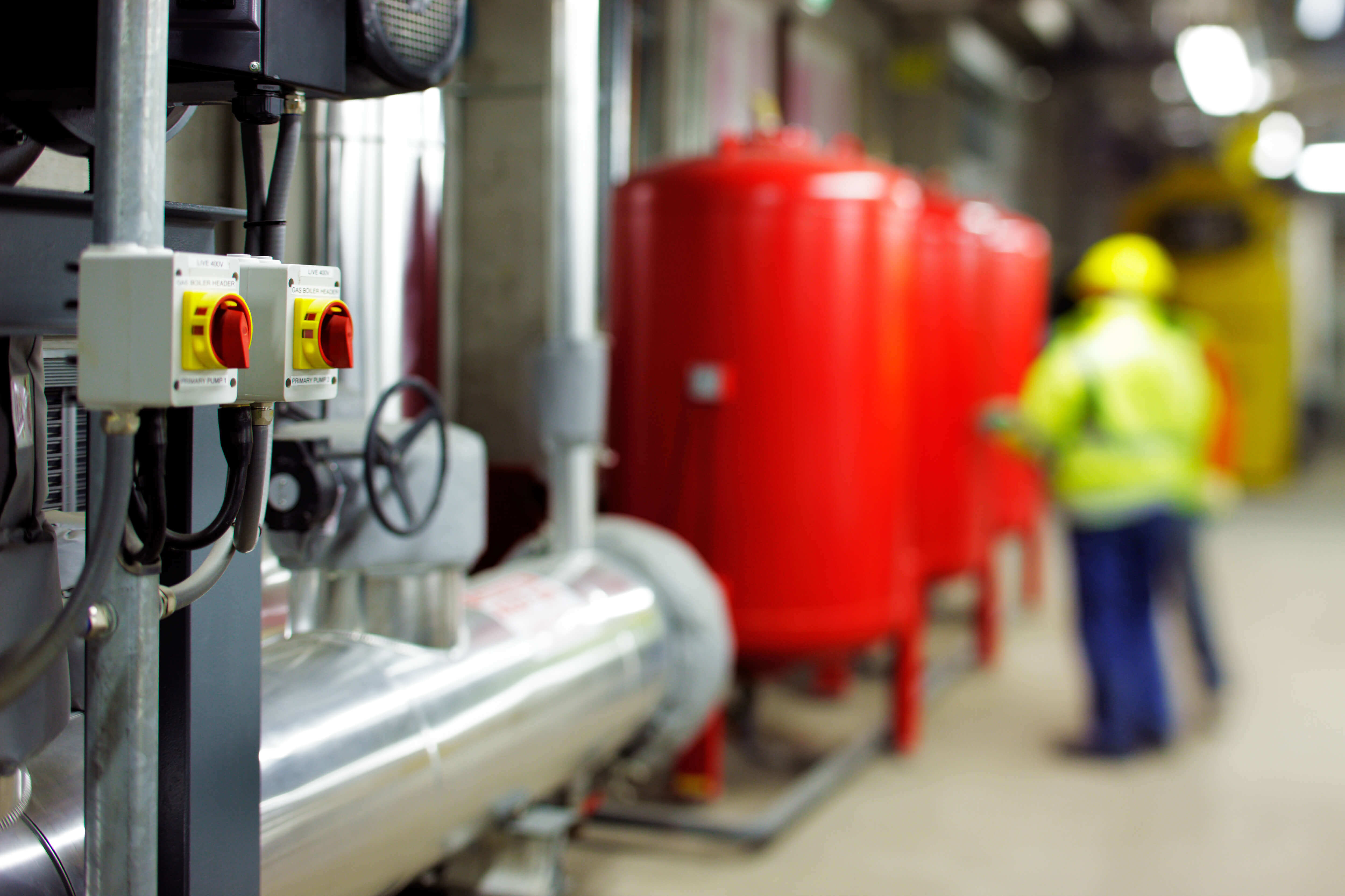 Switches, tanks, and a worker on the inside of a facility
