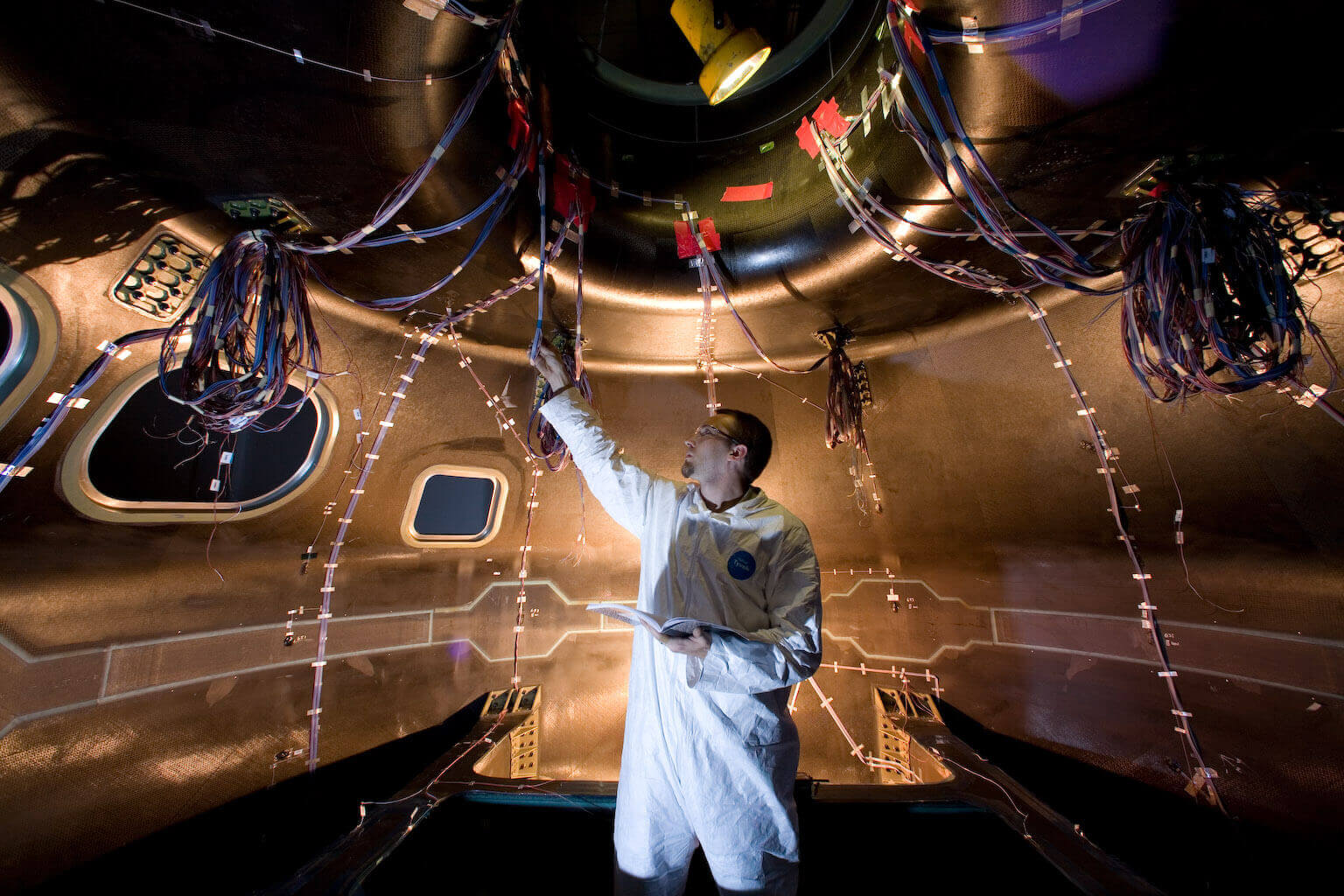 NASA engineer checking electrical systems on the Orion spacecraft