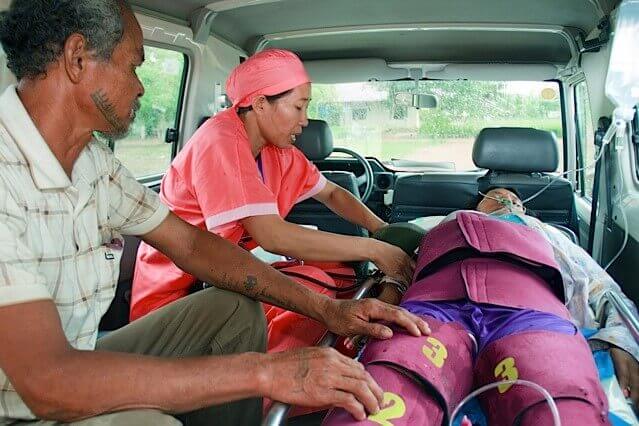 Workers apply a pressure garment to a woman 