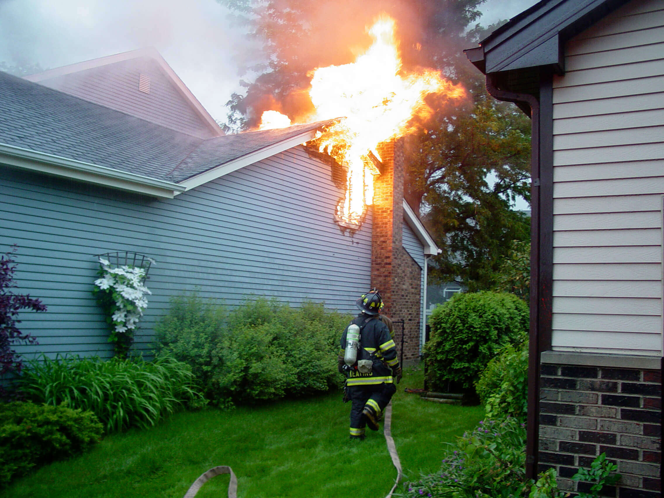 Firefighter preparing to put out house fire 