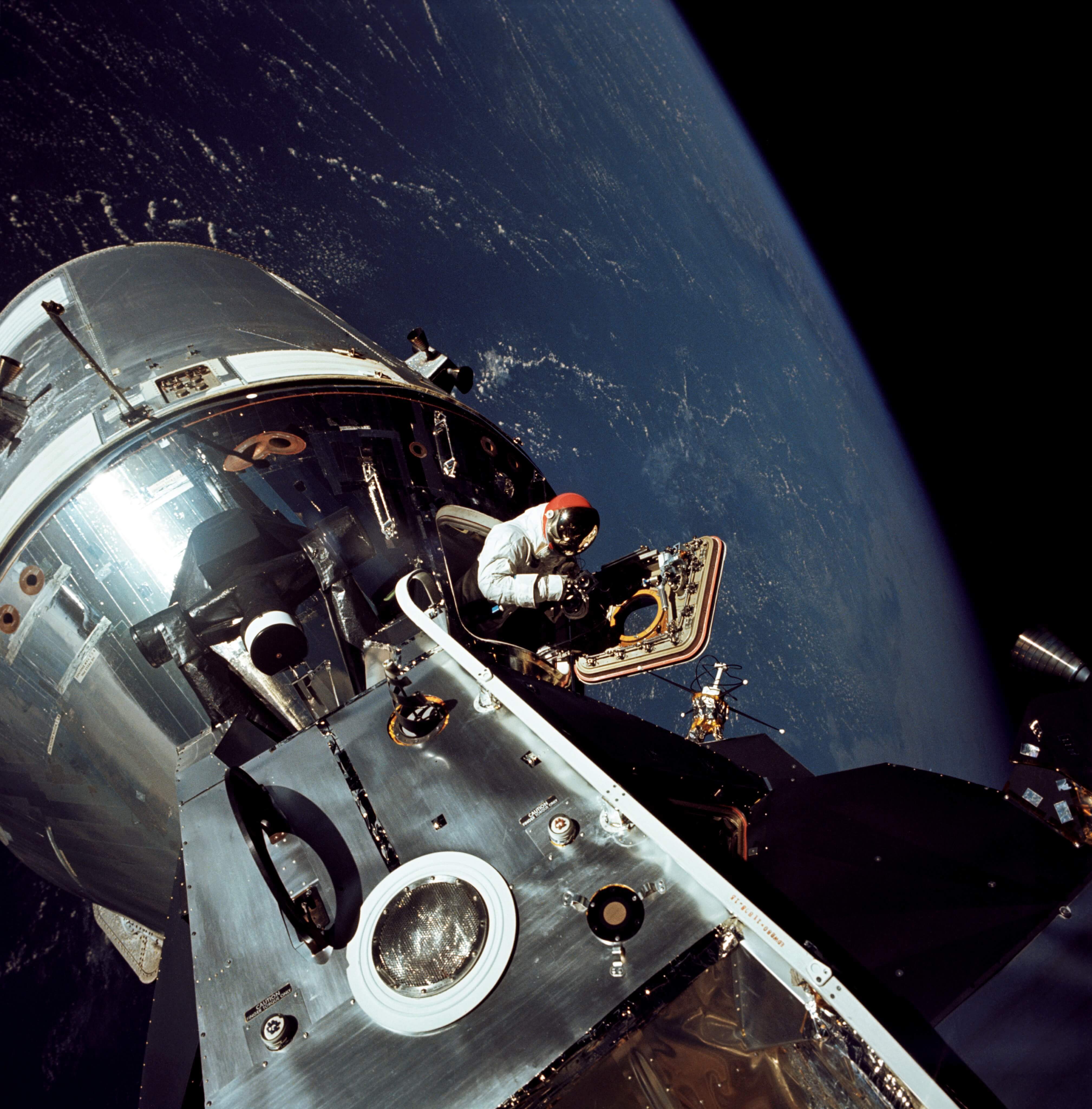 Astronaut leaving Apollo 9 command/service module docked with lunar module 