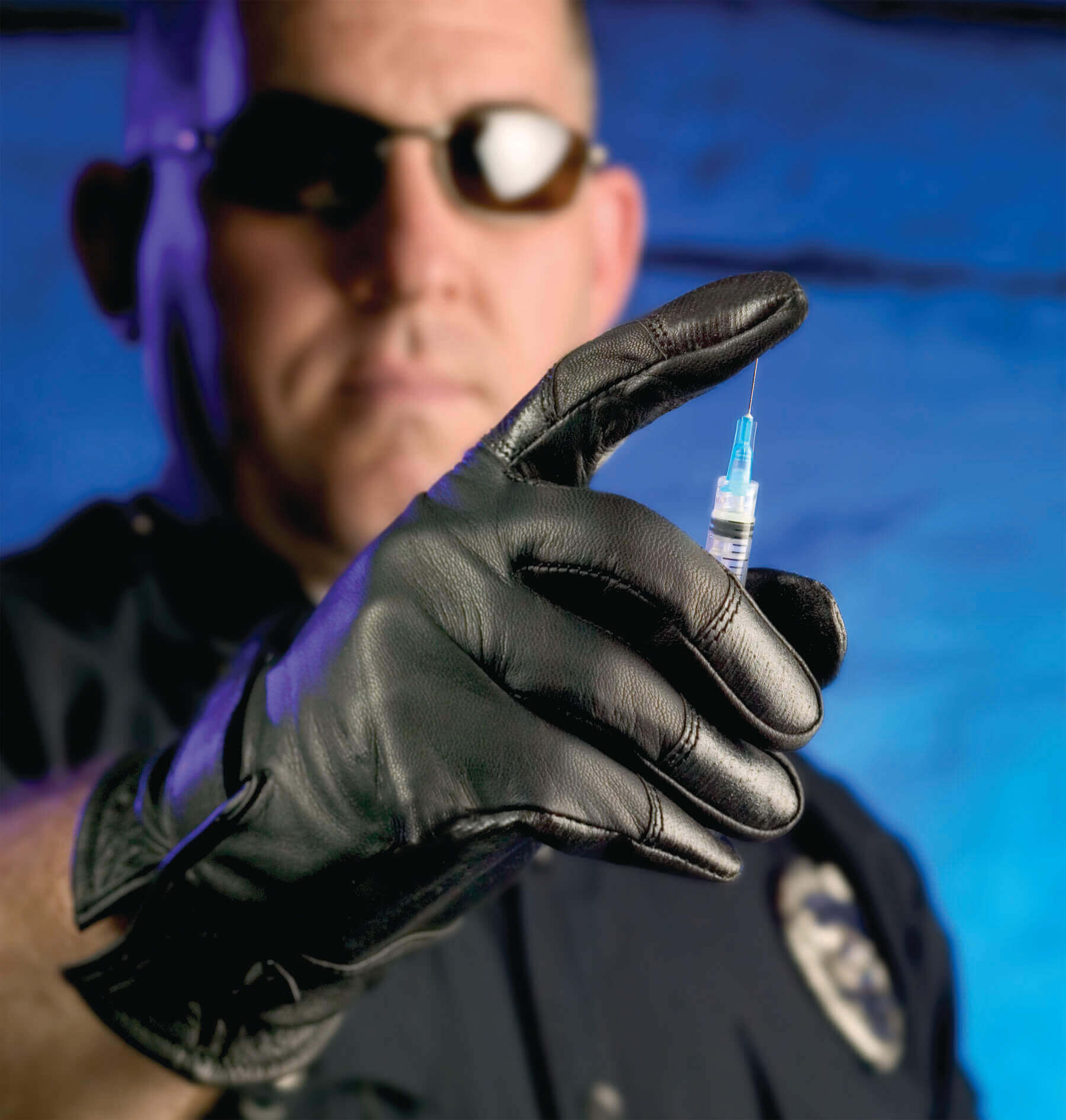 Man using a needle to demonstrate glove's strength 