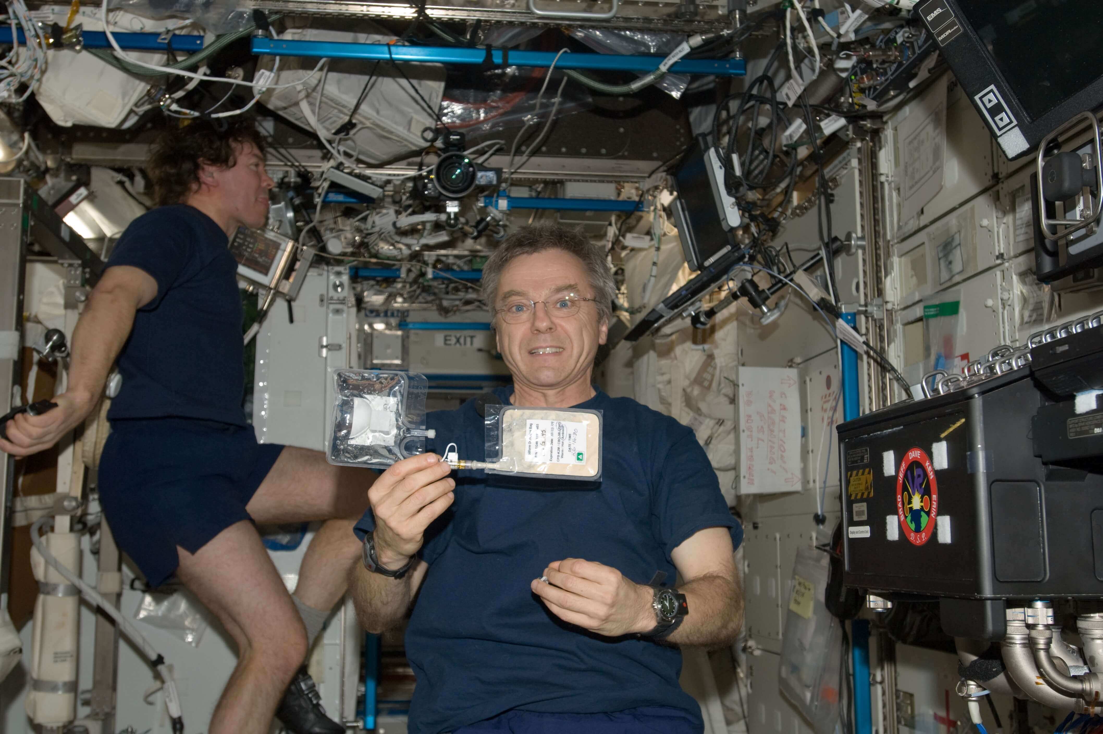 Astronaut with a coliform bacteria test kit on the International Space Station 