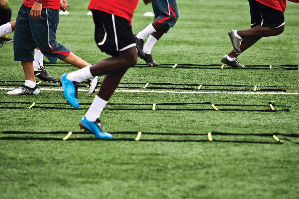 The legs of runners on a field 