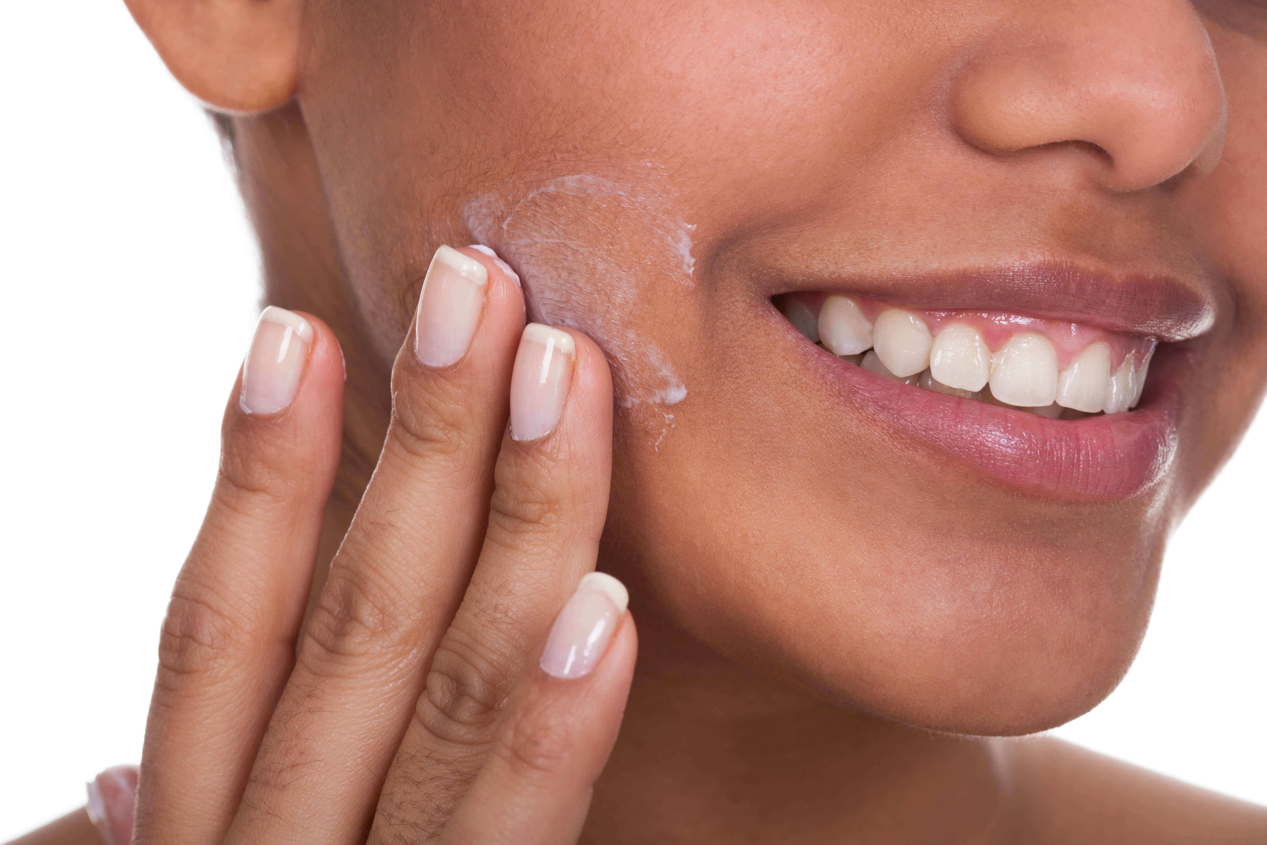 Woman applying skin cream to her face