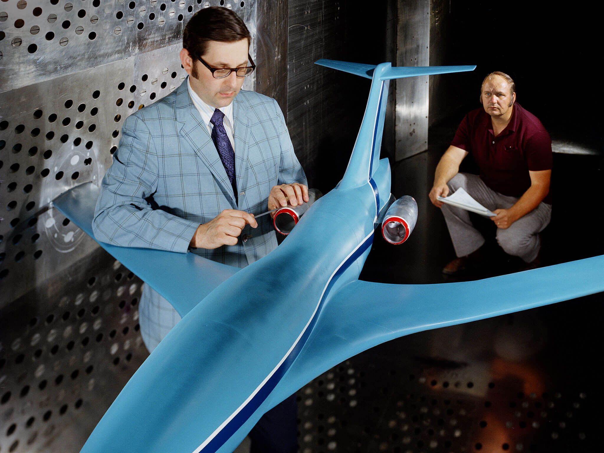 NASA researchers working in a wind tunnel on an aircraft model