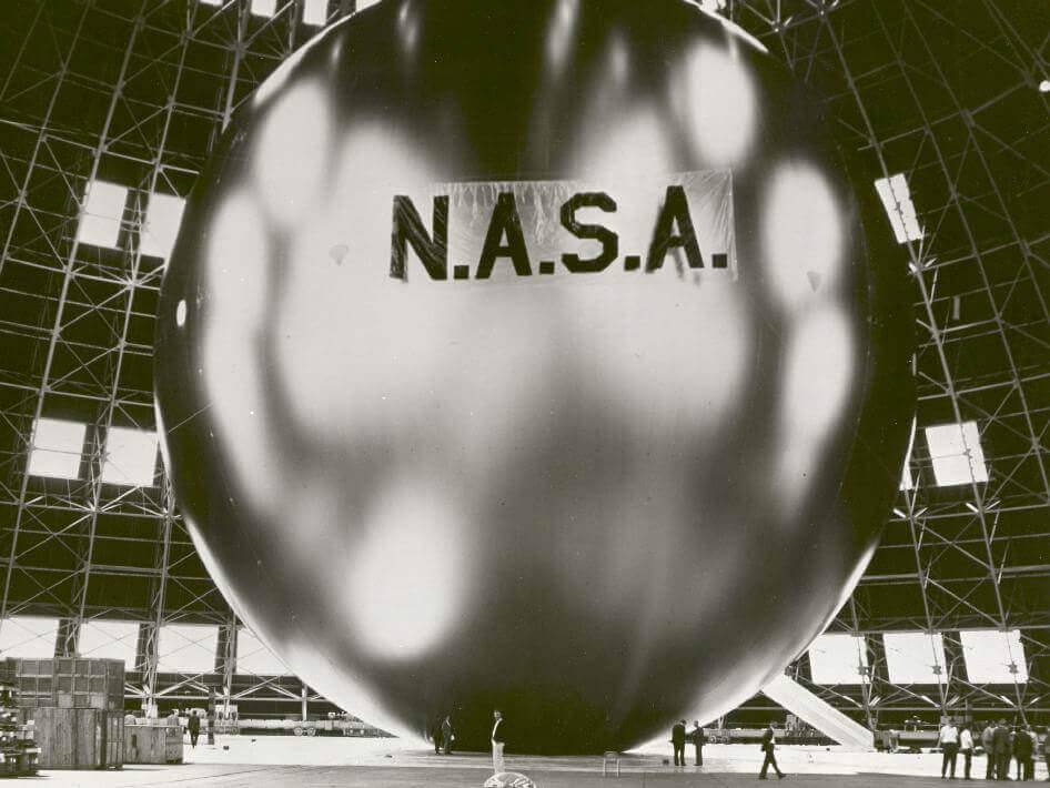 People dwarfed by NASA's Echo II Mylar balloon satellite 