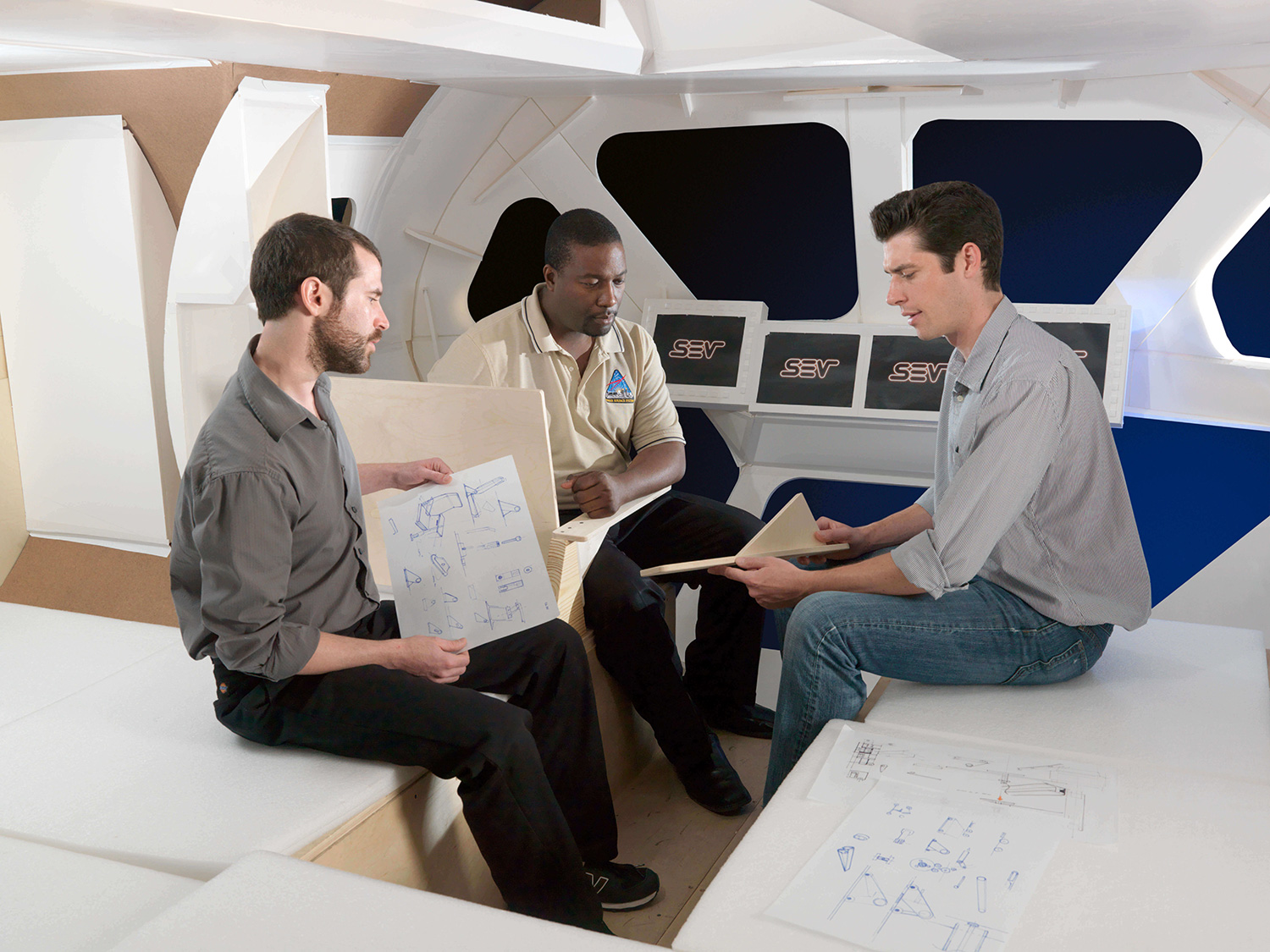 NASA Habitability Design Center engineers discussing plans in a mockup of the Space Exploration Vehicle 