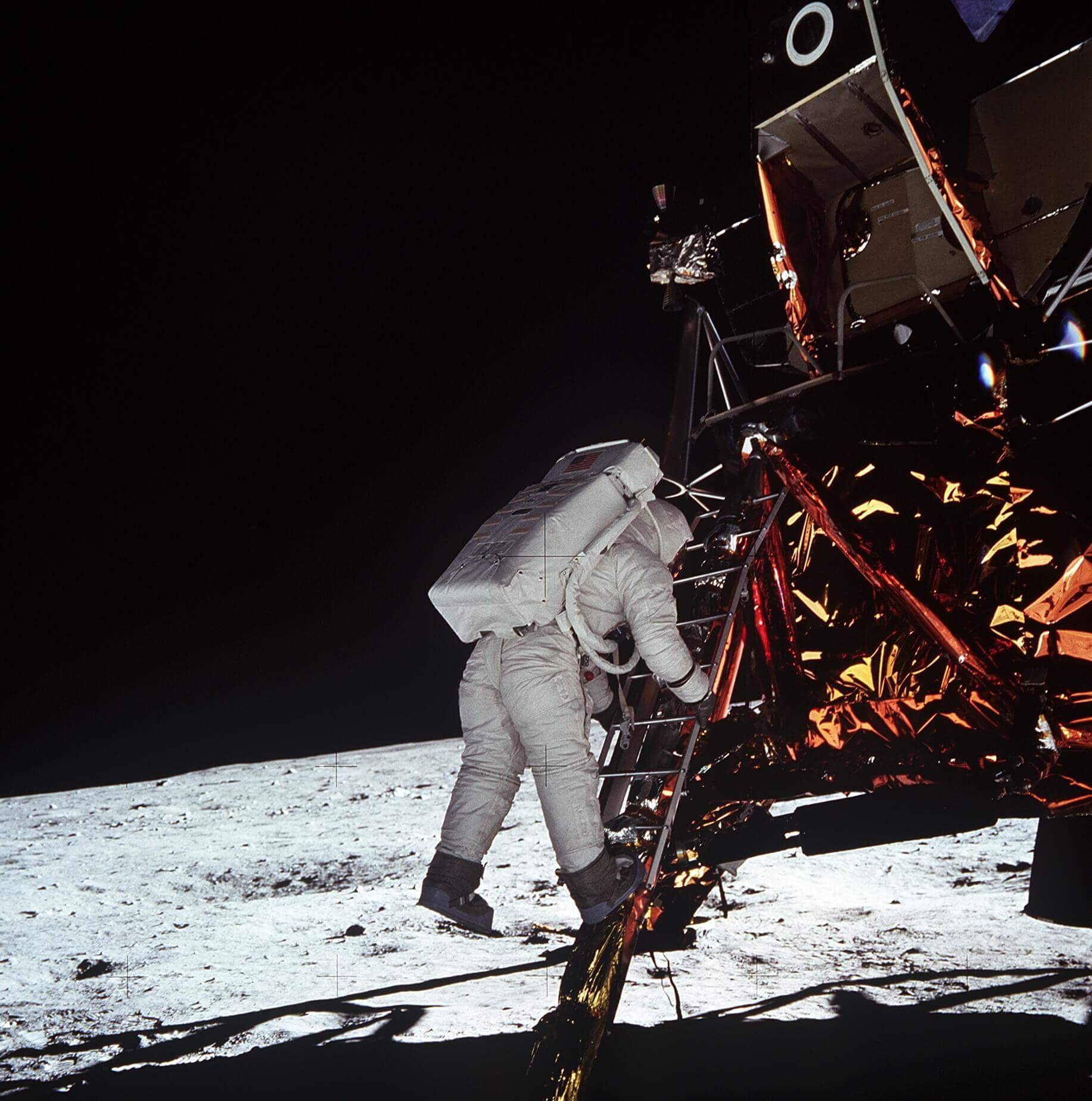 Apollo astronaut descending the lunar lander's ladder