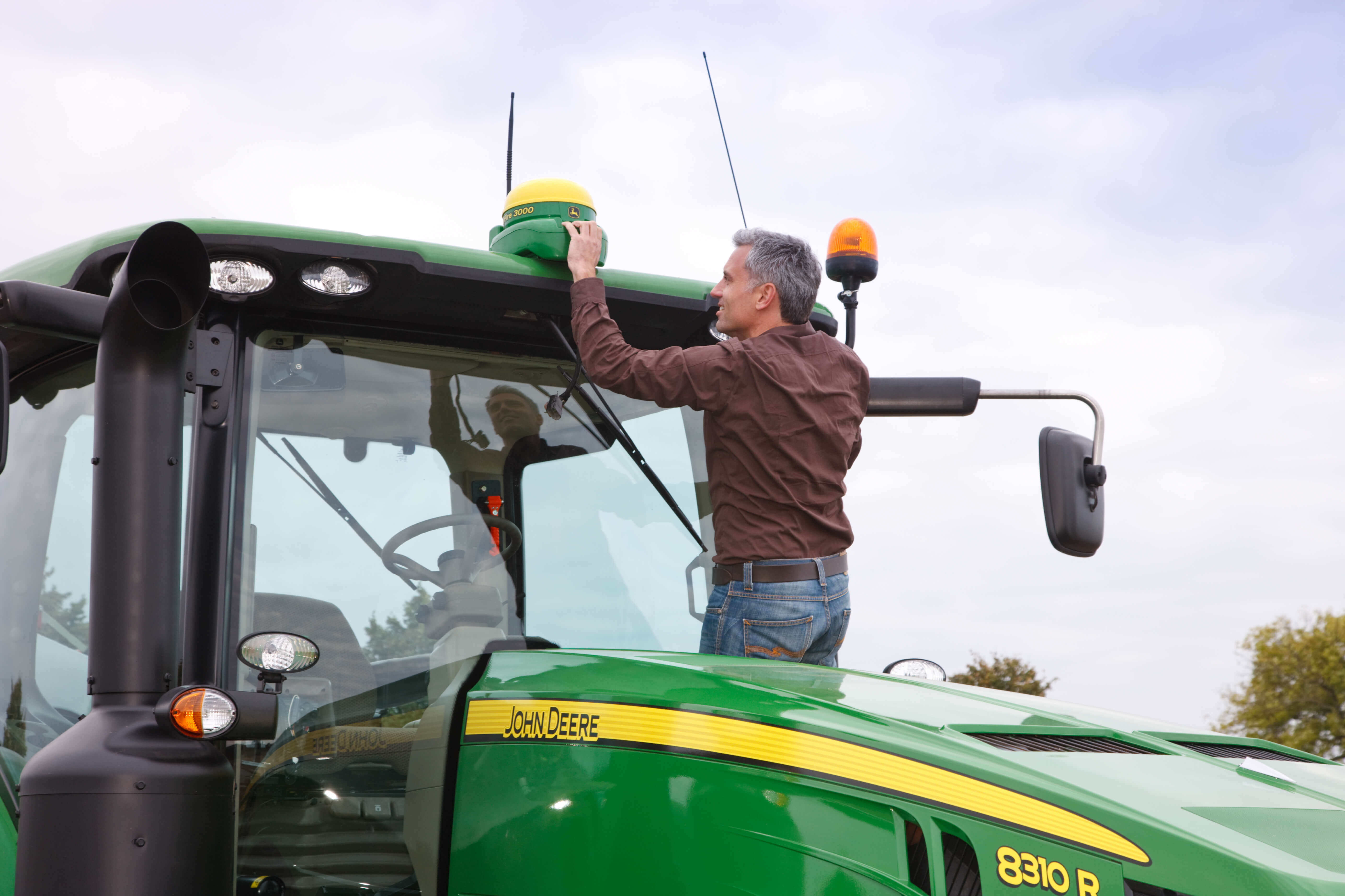 Man attaching a positioning device to his tractor